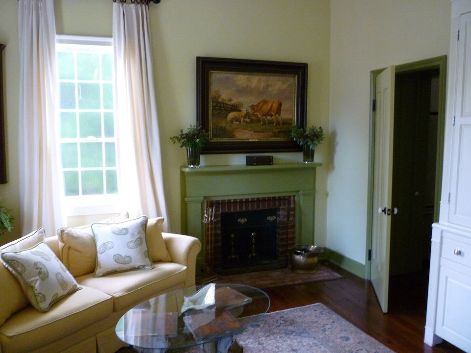 Bright living room with a cream sofa, glass coffee table and a brick fireplace